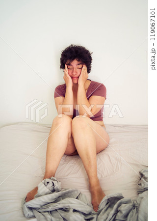 tired young plus size woman in home clothes on bed in student dormitory tired young plus size woman in home clothes on bed in student dormitory 119067101