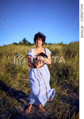 young plus size woman walking and playing with her pet rabbit by the sea in Copenhagen 119067148