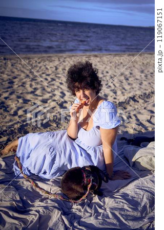 young plus size woman eating carrots with her pet rabbit by the sea in copenhagen young plus size woman eating carrots with her pet rabbit by the sea in copenhagen 119067151