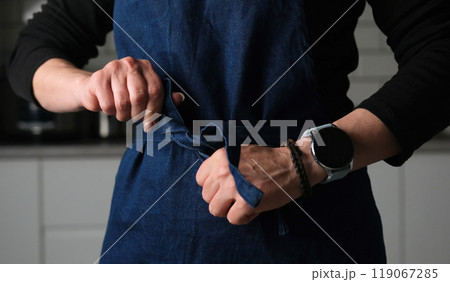 Woman Tying A Chief Apron In The Kitchen Woman Tying A Chief Apron In The Kitchen 119067285
