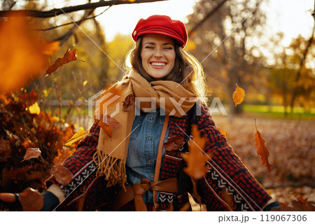 Portrait of smiling young woman throwing autumn leafs Portrait of smiling young woman throwing autumn leafs 119067306