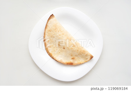 Minimalist composition of a simple taco on a white plate high key lighting 119069184