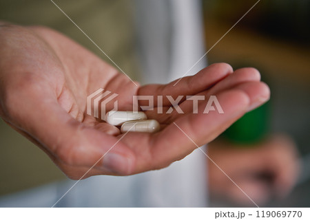 Woman holds pills in hand. Person takes dietary supplements and vitamins. Daily medical procedure to maintain health 119069770