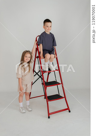 Little couple kids boy girl 4-5 years old clothes shirt dress posing have fun isolated on white background children studio portrait. People childhood lifestyle 119070001