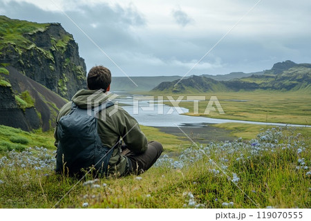 sitting man relaxes against a beautiful natural landscape 119070555