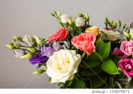 Celebrate special occasions with a colorful summer bouquet featuring fresh roses, eucalyptus, and eustoma blooms, creating an elegant and fragrant floral arrangement 119070671