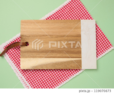 Empty rectangular wooden kitchen cutting board on green background 119070873