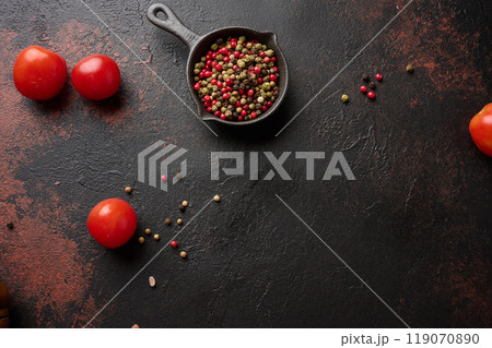Culinary composition with kitchen utensils and spices,  colorful peppercorns, fresh tomatoes on the table. Top view 119070890