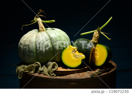 Green pumpkins on metal rusty barrel 119071230
