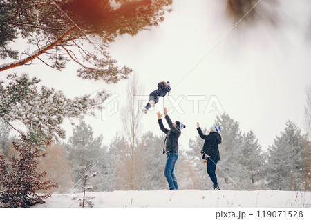 Family have fun in a winter park. Stylish mother in a blue jacket. Little girl in a winter clothes. Father with cute daughter 119071528