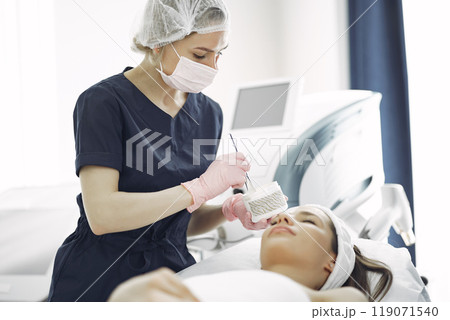 Cosmetologist treats client's skin. Woman with cosmetologist. Lady in a beauty studio. 119071540