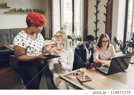 African man. Guy in a black suit. Students with a laptop. Girl in white blouse. International people in a cafe. 119071570