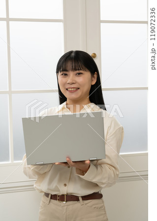 立ってノートパソコンの操作をする女性 立ってノートパソコンの操作をする女性 119072336