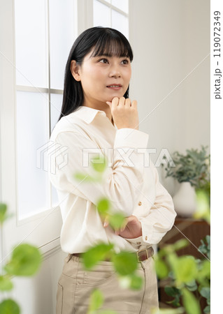 窓際に立ってポーズをとる女性 119072349
