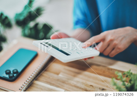 電卓を操作する女性の手元 119074326