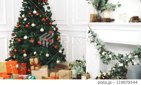 Background Christmas tree decorated holiday winter xmas celebration present gift decorate bauble ornament golden ball in cozy living room. Merry Christmas happy new year festival traditional concept 119078544