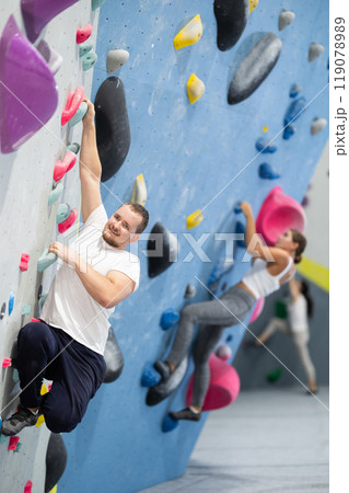Young man practicing rock climbing on climbing wall Young man practicing rock climbing on climbing wall 119078989