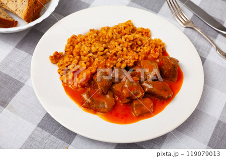 There is portion of hearty food on plate - pearl barley with beef stew in tomato sauce 119079013
