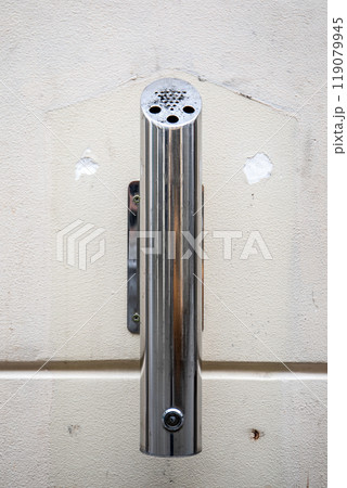 Chrome ashtray at the facade of the building 119079945