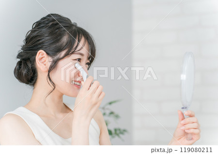 目元のシワ・たるみを美容グッズでケアするアジア人女性 119080211