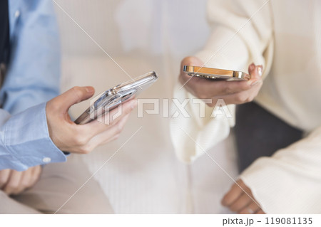 スマホの連絡先を交換する若い女性 スマホの連絡先を交換する若い女性 119081135