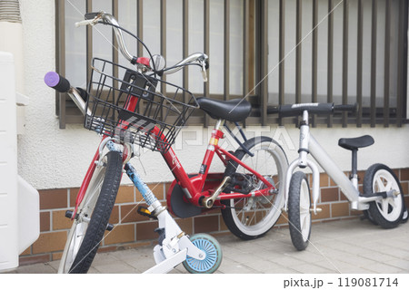 家の前に置かれた子供用自転車とストライダーとキックボード 119081714