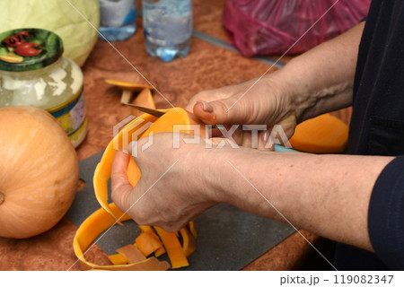 A woman cleans a pumpkin for cooking. 119082347