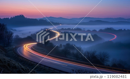 Winding road, bathed in twilight serenity, adorned with light trails 119082481