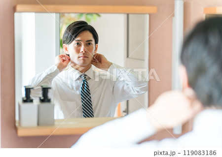 朝出勤前にヘアセットするスーツ姿の若いアジア人男性ビジネスマン 朝出勤前にヘアセットするスーツ姿の若いアジア人男性ビジネスマン 119083186