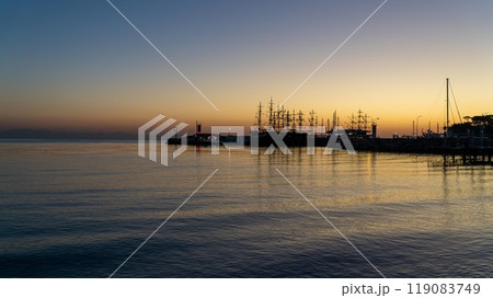 Sunrise at Kemer yacht marina in Antalya, Turkiye. The calm sea reflects the orange sky, capturing the serene beauty of this popular summer vacation spot. Sunrise at Kemer yacht marina in Antalya, Turkiye. The calm sea reflects the orange sky, capturing the serene beauty of this popular summer vacation spot. 119083749