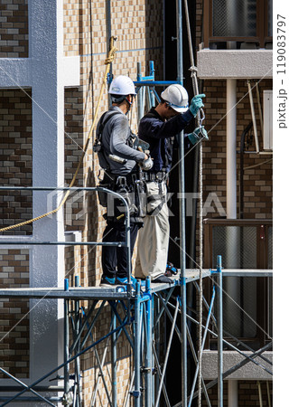 マンションの大規模修繕工事現場で安全第一に足場架設工事を行う鳶職人 119083797