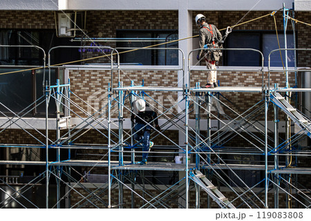 マンションの大規模修繕工事現場で安全第一に足場架設工事を行う鳶職人 119083808