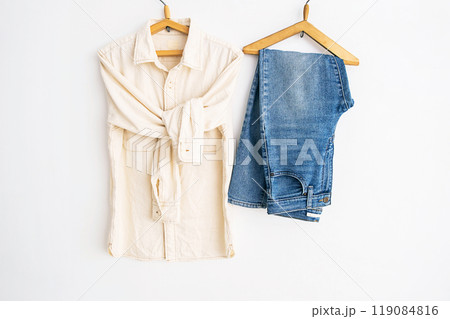 Shirt and jeans hanging on wooden hangers. Casual fashion concept. 119084816