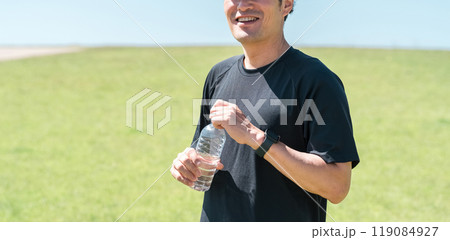 運動中に水・ミネラルウォーターを飲む男性（水分補給・運動・ワークアウト・ランニング・ウォーキング） 119084927