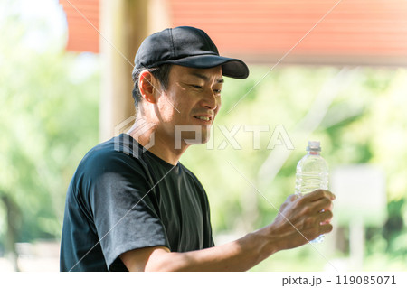 運動中に水・ミネラルウォーターを飲む男性（水分補給・運動・ワークアウト・ランニング・ウォーキング） 119085071