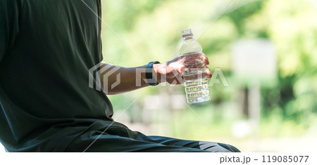 運動中に水・ミネラルウォーターを飲む男性（水分補給・運動・ワークアウト・ランニング・ウォーキング） 119085077