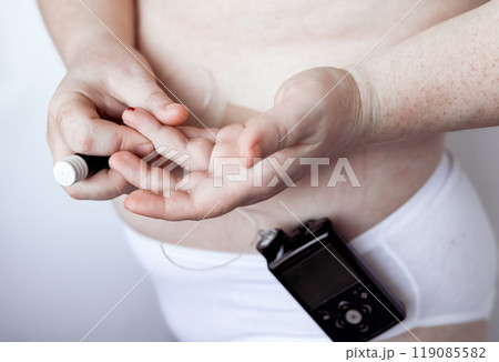 Person checking blood sugar level with diabetes monitor device 119085582