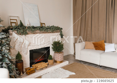 Cozy living room with a fireplace, a couch, and a Christmas tree. Perfect for relaxing and spending time with family Cozy living room with a fireplace, a couch, and a Christmas tree. Perfect for relaxing and spending time with family 119085625