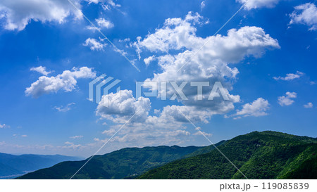 初夏の青空のもと、山頂に流れるたくさんの白い雲 初夏の青空のもと、山頂に流れるたくさんの白い雲 119085839