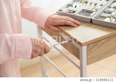 新しいキッチンラックを組み立てるミドル女性 新しいキッチンラックを組み立てるミドル女性 119086111
