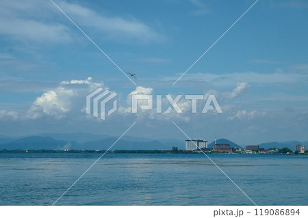 入道雲沸き立つ空と湖面の向こうに見える長浜市街地 119086894