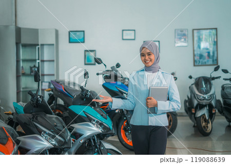Muslim female shop assistant stands with a gesture of presenting something 119088639