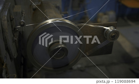 Industrial Rotating Machine with wire. Creative. Rotating coils winding wire at factory. Industrial workshop with wire on rotating machines of metallurgical production Industrial Rotating Machine with wire. Creative. Rotating coils winding wire at factory. Industrial workshop with wire on rotating machines of metallurgical production 119088694