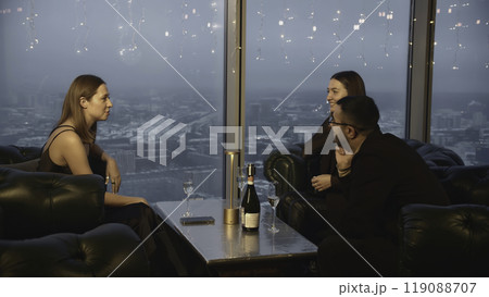 Group of friends are talking in restaurant. Media. Friends are chatting in company in restaurant. Three friends chat in restaurant on background of dark winter city Group of friends are talking in restaurant. Media. Friends are chatting in company in restaurant. Three friends chat in restaurant on background of dark winter city 119088707