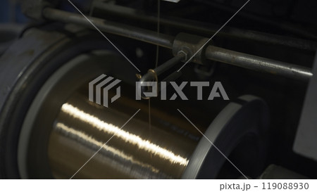 Close-up of coil winding copper wire. Creative. Shiny copper wire is wound on coil at metallurgical plant. Production of copper wires Close-up of coil winding copper wire. Creative. Shiny copper wire is wound on coil at metallurgical plant. Production of copper wires 119088930
