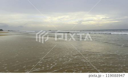 Beautiful landscape of sandy beach with long waves. Action. Beautiful calm beach with long moving waves. Beautiful seascape of sandy beach in tropical zone Beautiful landscape of sandy beach with long waves. Action. Beautiful calm beach with long moving waves. Beautiful seascape of sandy beach in tropical zone 119088947