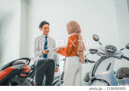 a sales man gives a brochure to a female visitor a sales man gives a brochure to a female visitor 119088980