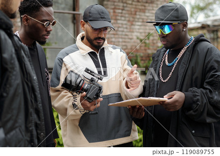 Reviewing Footage on Set with Group of Male Filmmakers 119089755