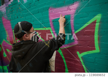 Spraying pink paint from can on wall 119089832