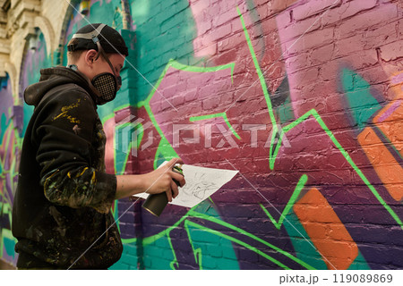 Guy looking at graffiti sketch on paper 119089869